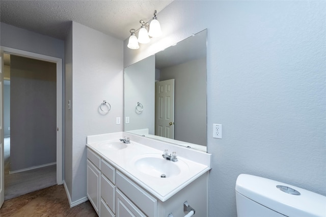 9405 Meyers Cyn, Plano, TX 75025 - bathroom featuring double vanity, toilet, a textured ceiling, and baseboards