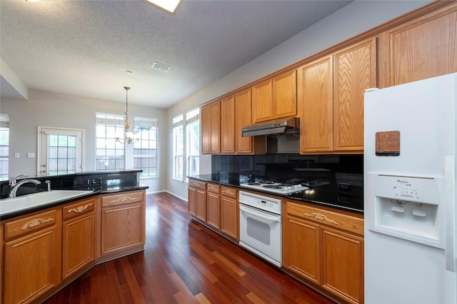 9405 Meyers Cyn, Plano, TX 75025 - kitchen with white appliances, under cabinet range hood, dark wood-type flooring, dark countertops, and a textured ceiling