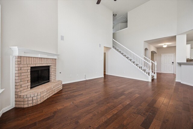 11181 Clearstream Ln, Frisco, TX 75035 - unfurnished living room featuring stairs, hardwood / wood-style floors, a high ceiling, a fireplace, and ceiling fan