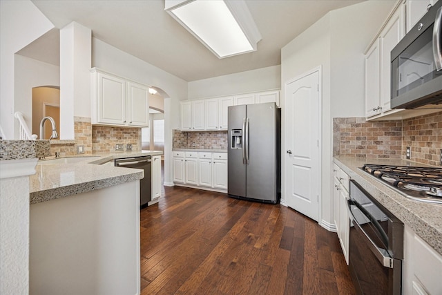 11181 Clearstream Ln, Frisco, TX 75035 - kitchen featuring appliances with stainless steel finishes, dark wood-style floors, white cabinets, and backsplash