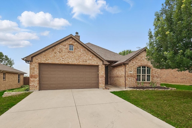 237 Cedar Crest Dr, Justin, TX 76247 - view of front facade with brick siding, concrete driveway, a front lawn, a garage, and a chimney