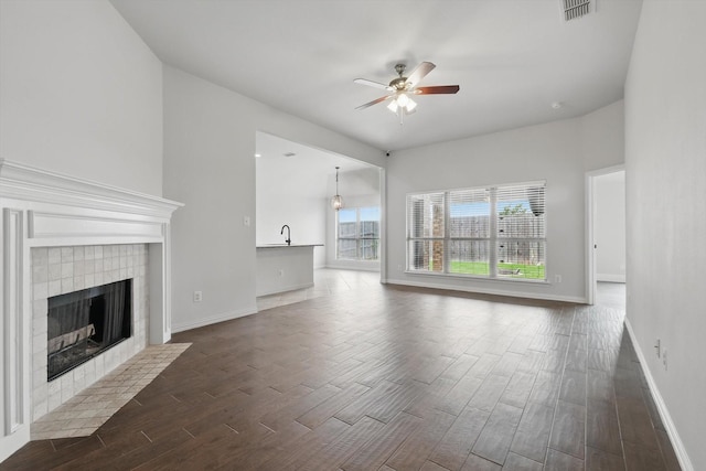 237 Cedar Crest Dr, Justin, TX 76247 - unfurnished living room featuring ceiling fan, dark wood-style flooring, a fireplace, baseboards, and a sink