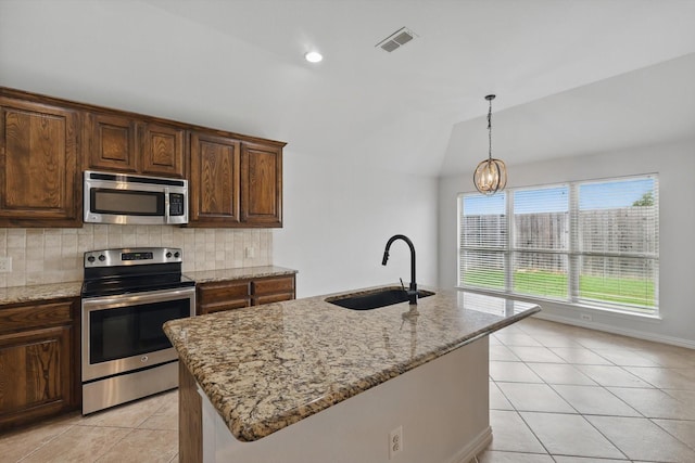 237 Cedar Crest Dr, Justin, TX 76247 - kitchen featuring stainless steel appliances, a sink, light tile patterned flooring, tasteful backsplash, and light stone countertops