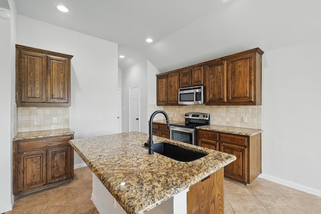 237 Cedar Crest Dr, Justin, TX 76247 - kitchen with stainless steel appliances, a sink, light stone counters, tasteful backsplash, and light tile patterned flooring