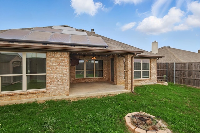 237 Cedar Crest Dr, Justin, TX 76247 - back of property with brick siding, an outdoor fire pit, a patio area, and roof mounted solar panels