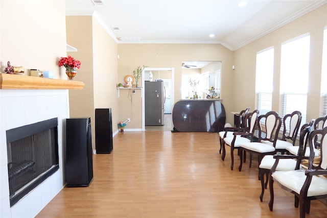 2003 Hearthside Ln, Garland, TX 75044 - dining space featuring healthy amount of natural light, light wood finished floors, ornamental molding, a tile fireplace, and recessed lighting