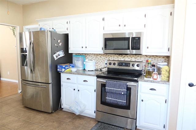 2003 Hearthside Ln, Garland, TX 75044 - kitchen with appliances with stainless steel finishes, white cabinets, decorative backsplash, and light tile patterned floors
