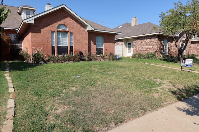 2003 Hearthside Ln, Garland, TX 75044 - ranch-style home with brick siding, a chimney, and a front yard