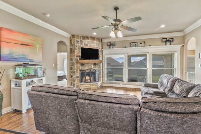 183 Melbourne Dr, Willow Park, TX 76087 - living room featuring arched walkways, ornamental molding, wood finished floors, a ceiling fan, and a stone fireplace