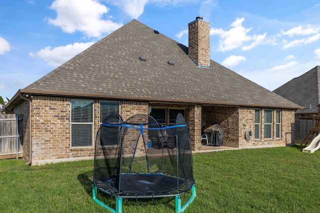 183 Melbourne Dr, Willow Park, TX 76087 - rear view of property with a trampoline, brick siding, a chimney, a shingled roof, and a patio area