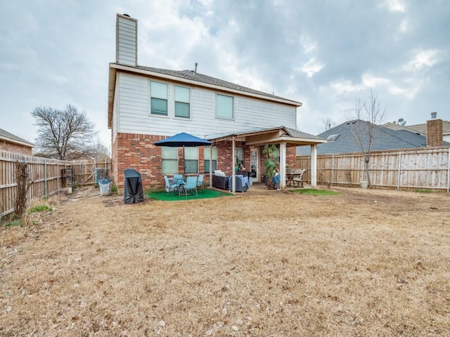 2852 Ector Dr, Grand Prairie, TX 75052 - back of house with brick siding, a patio, a chimney, and a fenced backyard