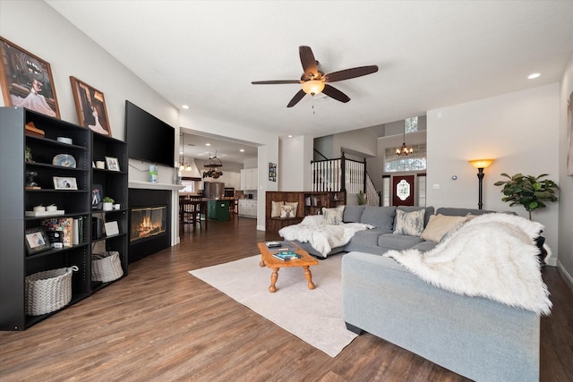 1817 Meadow Ridge Dr, Flower Mound, TX 75028 - living area with a glass covered fireplace, a ceiling fan, stairway, wood finished floors, and recessed lighting