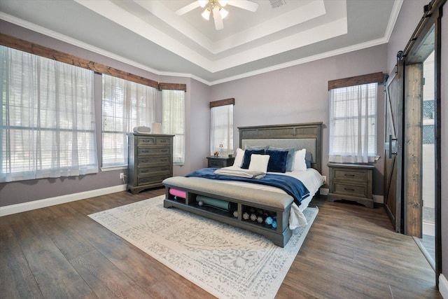 1817 Meadow Ridge Dr, Flower Mound, TX 75028 - bedroom with a barn door, a tray ceiling, dark wood-style flooring, and baseboards