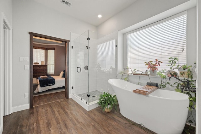 1817 Meadow Ridge Dr, Flower Mound, TX 75028 - ensuite bathroom featuring wood finished floors, a stall shower, a freestanding tub, healthy amount of natural light, and recessed lighting