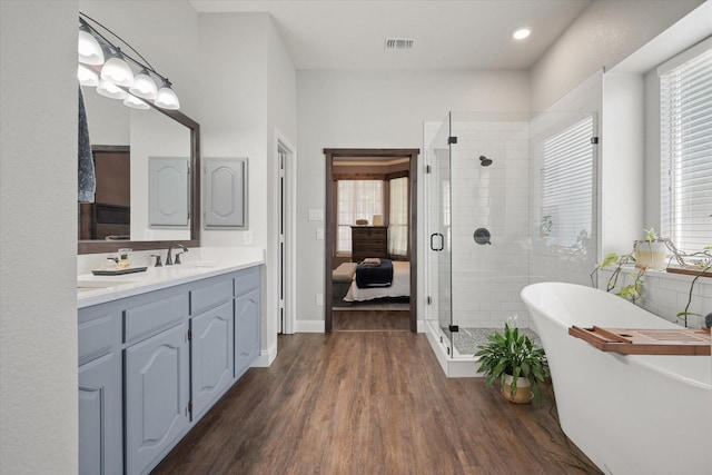 1817 Meadow Ridge Dr, Flower Mound, TX 75028 - bathroom with vanity, a shower stall, a soaking tub, wood finished floors, and recessed lighting