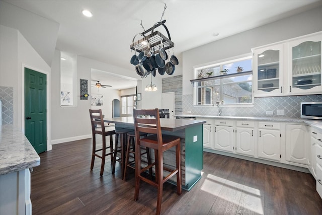 1817 Meadow Ridge Dr, Flower Mound, TX 75028 - kitchen with stainless steel microwave, white cabinetry, tasteful backsplash, dark wood-style floors, and recessed lighting