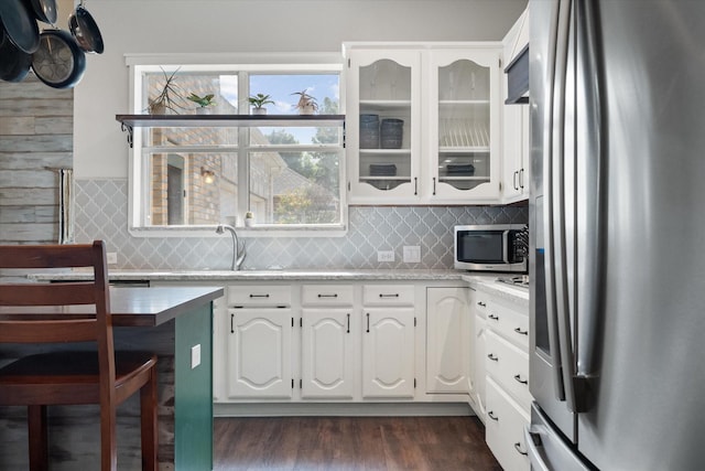 1817 Meadow Ridge Dr, Flower Mound, TX 75028 - kitchen with appliances with stainless steel finishes, white cabinetry, tasteful backsplash, and dark wood-style flooring