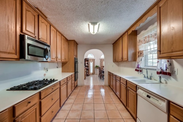 5310 Ranchero Ln, Dallas, TX 75236 - kitchen with stainless steel microwave, dishwasher, arched walkways, a sink, and black gas cooktop