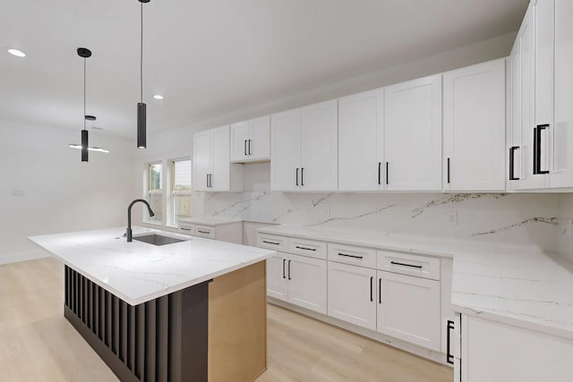 4519 Wahoo St, Dallas, TX 75210 - kitchen featuring light wood-type flooring, a sink, backsplash, recessed lighting, and light stone counters