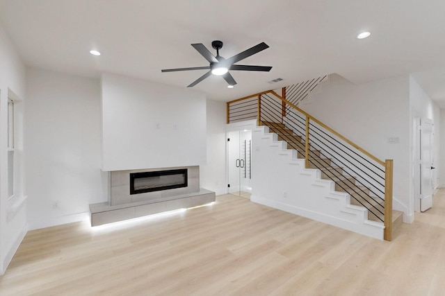 4519 Wahoo St, Dallas, TX 75210 - unfurnished living room featuring stairs, wood finished floors, a glass covered fireplace, ceiling fan, and recessed lighting
