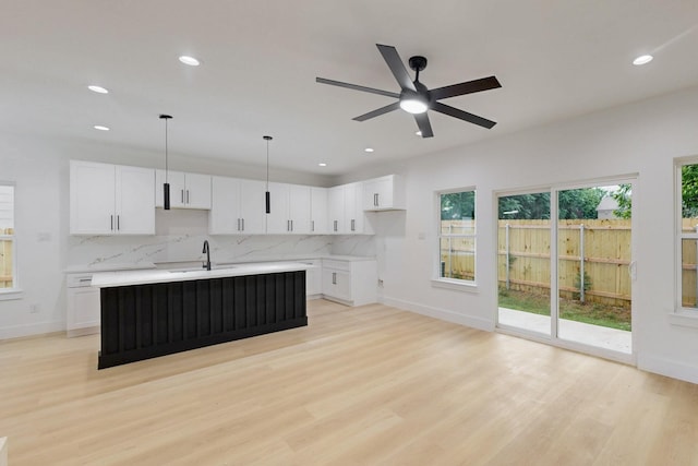4519 Wahoo St, Dallas, TX 75210 - kitchen with a sink, decorative backsplash, light wood finished floors, recessed lighting, and white cabinets