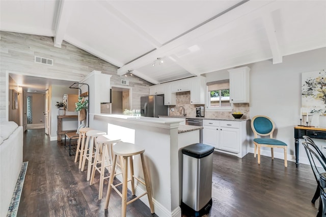 746 Greenhaven Dr, Richardson, TX 75080 - kitchen with stainless steel fridge with ice dispenser, a kitchen bar, white cabinets, and dark wood finished floors