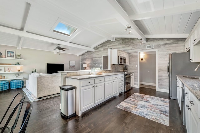 746 Greenhaven Dr, Richardson, TX 75080 - kitchen with appliances with stainless steel finishes, a sink, wood walls, white cabinetry, and light stone countertops