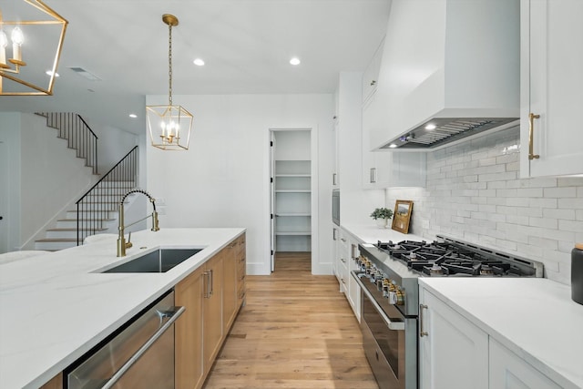 6607 Kenwell St, Dallas, TX 75209 - kitchen featuring stainless steel appliances, custom exhaust hood, a sink, a chandelier, and light wood-style floors