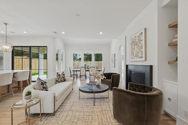 6607 Kenwell St, Dallas, TX 75209 - living room featuring a fireplace, recessed lighting, light wood-style floors, and a chandelier
