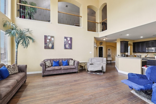 5400 Ivyridge Ln, Mckinney, TX 75071 - living room with wood finished floors, a high ceiling, and baseboards