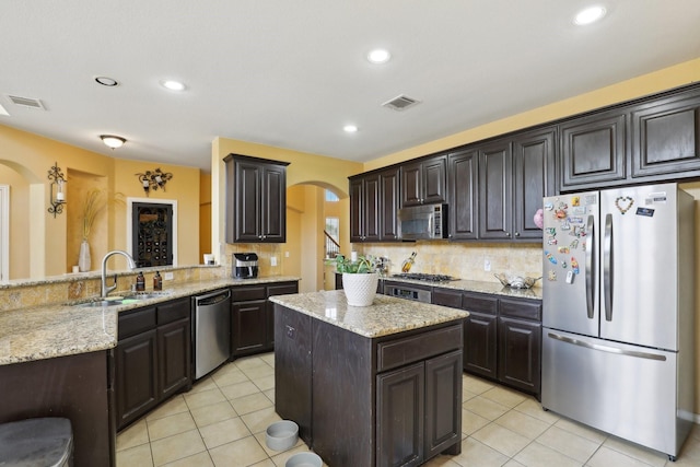 5400 Ivyridge Ln, Mckinney, TX 75071 - kitchen featuring stainless steel appliances, a sink, arched walkways, decorative backsplash, and recessed lighting