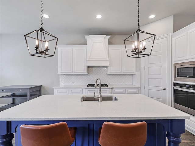 2815 Spring Creek Trl, Celina, TX 75078 - kitchen with a chandelier, stainless steel appliances, custom range hood, white cabinets, and decorative backsplash