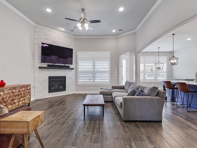 2815 Spring Creek Trl, Celina, TX 75078 - living area featuring a ceiling fan, dark wood-style flooring, a stone fireplace, recessed lighting, and arched walkways