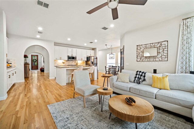 7812 Rockledge Dr, Mckinney, TX 75071 - living room featuring arched walkways, light wood-style floors, a ceiling fan, recessed lighting, and baseboards