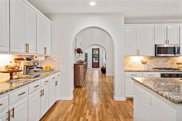 7812 Rockledge Dr, Mckinney, TX 75071 - kitchen featuring appliances with stainless steel finishes, arched walkways, white cabinetry, recessed lighting, and light wood-style floors
