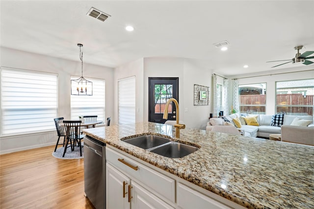 7812 Rockledge Dr, Mckinney, TX 75071 - kitchen with a sink, stainless steel dishwasher, light wood-style flooring, pendant lighting, and light stone countertops