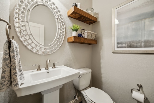 18261 Brighton Grn, Dallas, TX 75252 - bathroom featuring toilet, a textured wall, and a sink