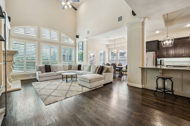 18261 Brighton Grn, Dallas, TX 75252 - living room featuring a chandelier, dark wood-type flooring, decorative columns, a ceiling fan, and baseboards