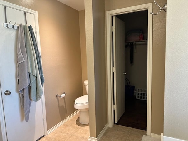 440 Maggie Cir, Flint, TX 75762 - bathroom featuring toilet, tile patterned flooring, baseboards, and a walk in closet
