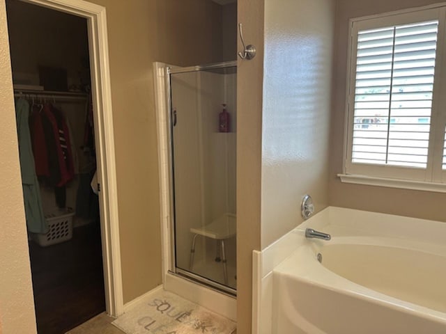 440 Maggie Cir, Flint, TX 75762 - bathroom featuring a stall shower, a bath, a walk in closet, and tile patterned flooring
