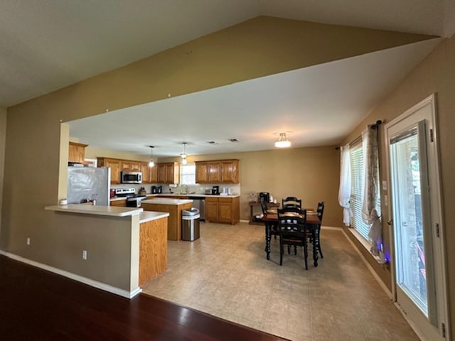 440 Maggie Cir, Flint, TX 75762 - kitchen with stainless steel appliances, brown cabinets, light countertops, a peninsula, and baseboards