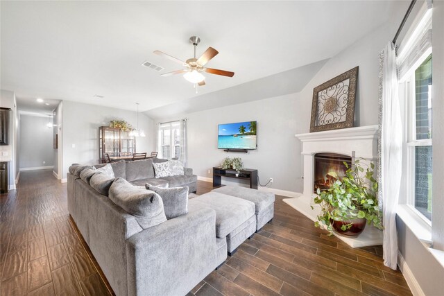 7524 Wispy Willow Ln, Little Elm, TX 76227 - living area featuring a ceiling fan, baseboards, a glass covered fireplace, dark wood-style floors, and vaulted ceiling