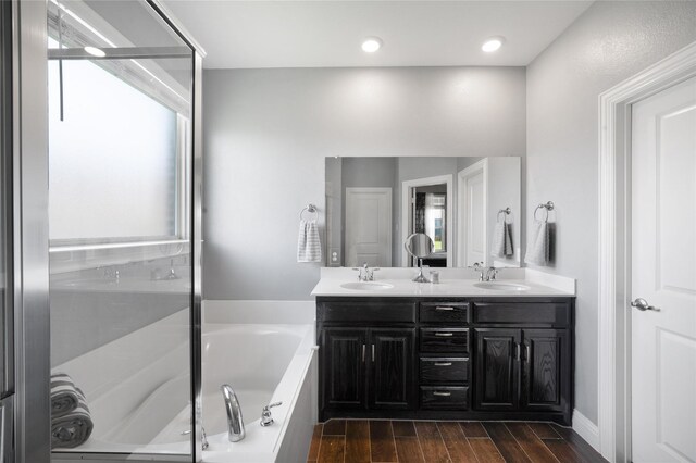 7524 Wispy Willow Ln, Little Elm, TX 76227 - bathroom with a bath, double vanity, wood finished floors, and recessed lighting