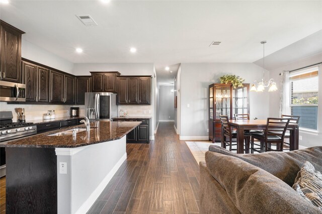 7524 Wispy Willow Ln, Little Elm, TX 76227 - kitchen featuring a sink, stainless steel appliances, dark wood finished floors, a kitchen island with sink, and baseboards