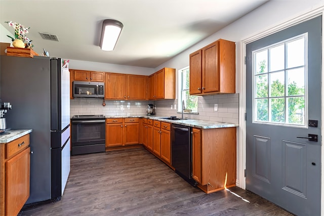 2036 Shawnee Trl, Fort Worth, TX 76247 - kitchen with appliances with stainless steel finishes, a sink, dark wood-style floors, decorative backsplash, and brown cabinetry