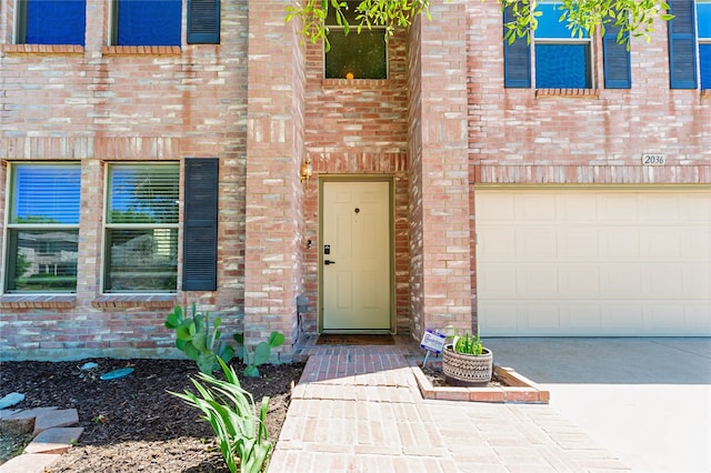 2036 Shawnee Trl, Fort Worth, TX 76247 - view of exterior entry with an attached garage, brick siding, and concrete driveway