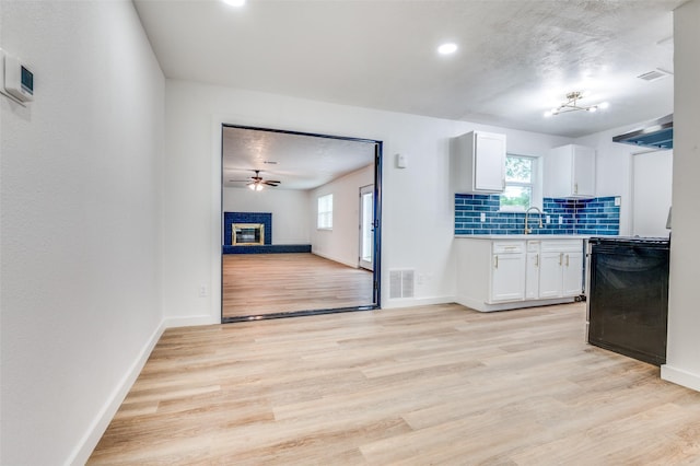 626 Thrush Ave, Duncanville, TX 75116 - kitchen featuring white cabinetry, light wood finished floors, light countertops, decorative backsplash, and plenty of natural light