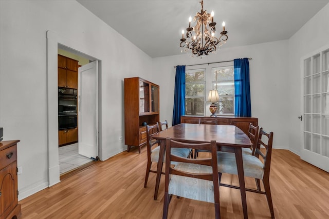 1710 Mckenzie Ave, Waco, TX 76708 - dining area with light wood-style floors, a chandelier, and baseboards