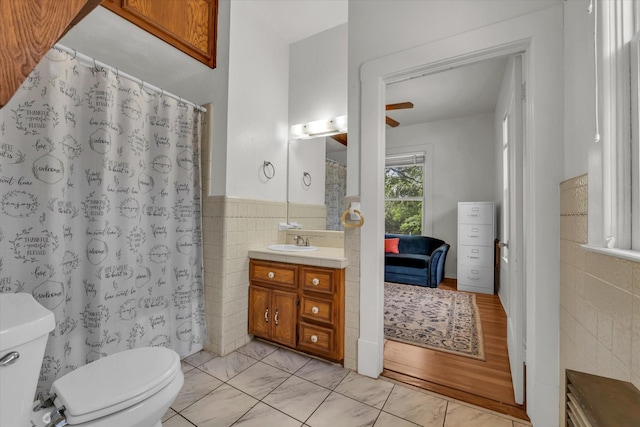 1710 Mckenzie Ave, Waco, TX 76708 - bathroom featuring tile walls, toilet, vanity, marble finish flooring, and wainscoting