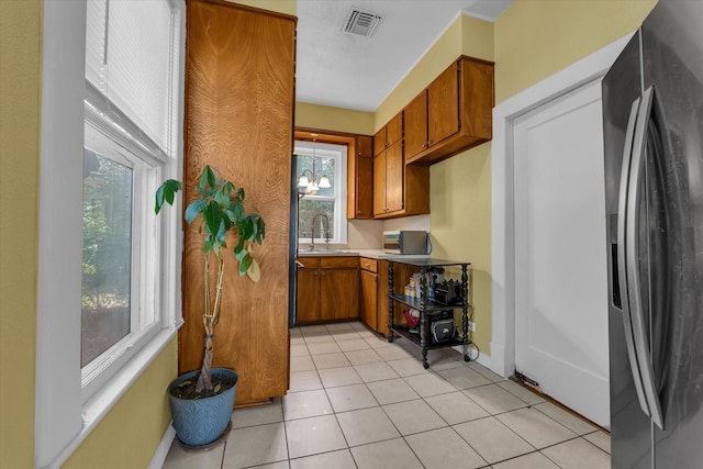 1710 Mckenzie Ave, Waco, TX 76708 - kitchen featuring stainless steel fridge with ice dispenser, brown cabinets, a sink, light countertops, and baseboards